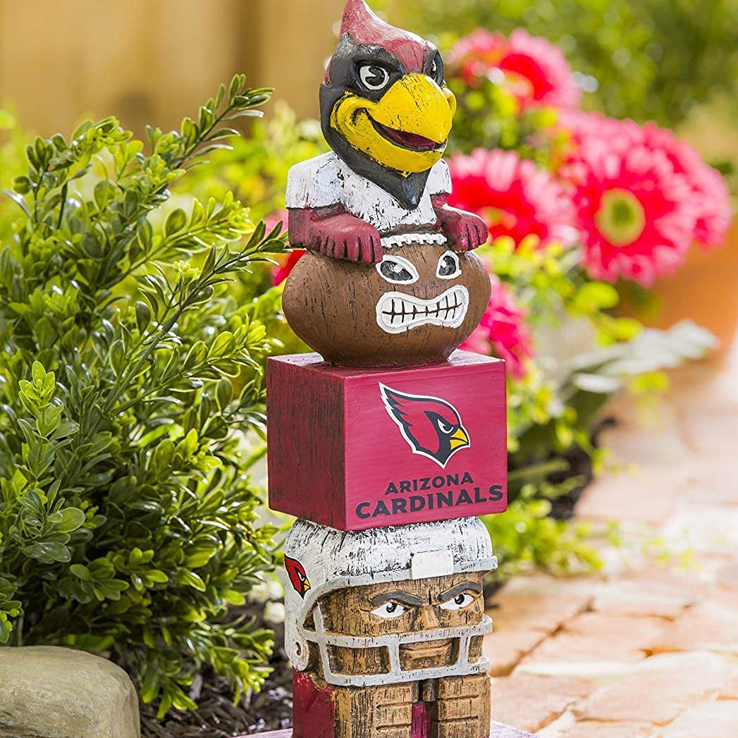 Arizona Cardinals-themed totem pole figurine with helmet, mask, and box on a garden path.