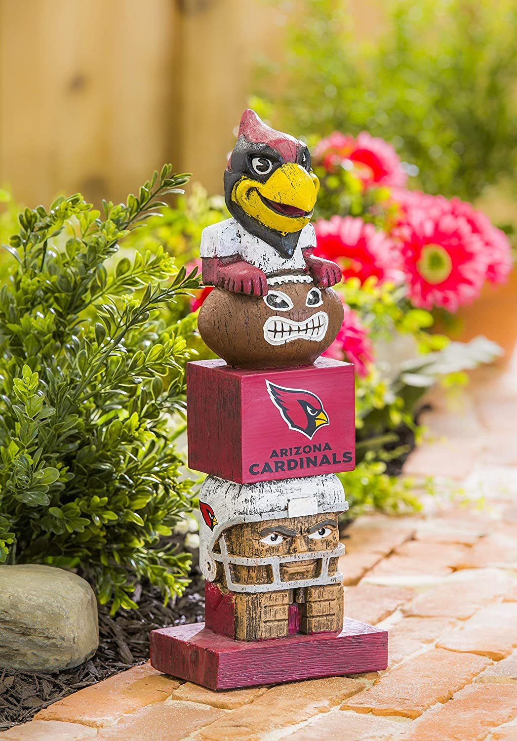 Arizona Cardinals-themed totem pole figurine with helmet, mask, and box on a garden path.