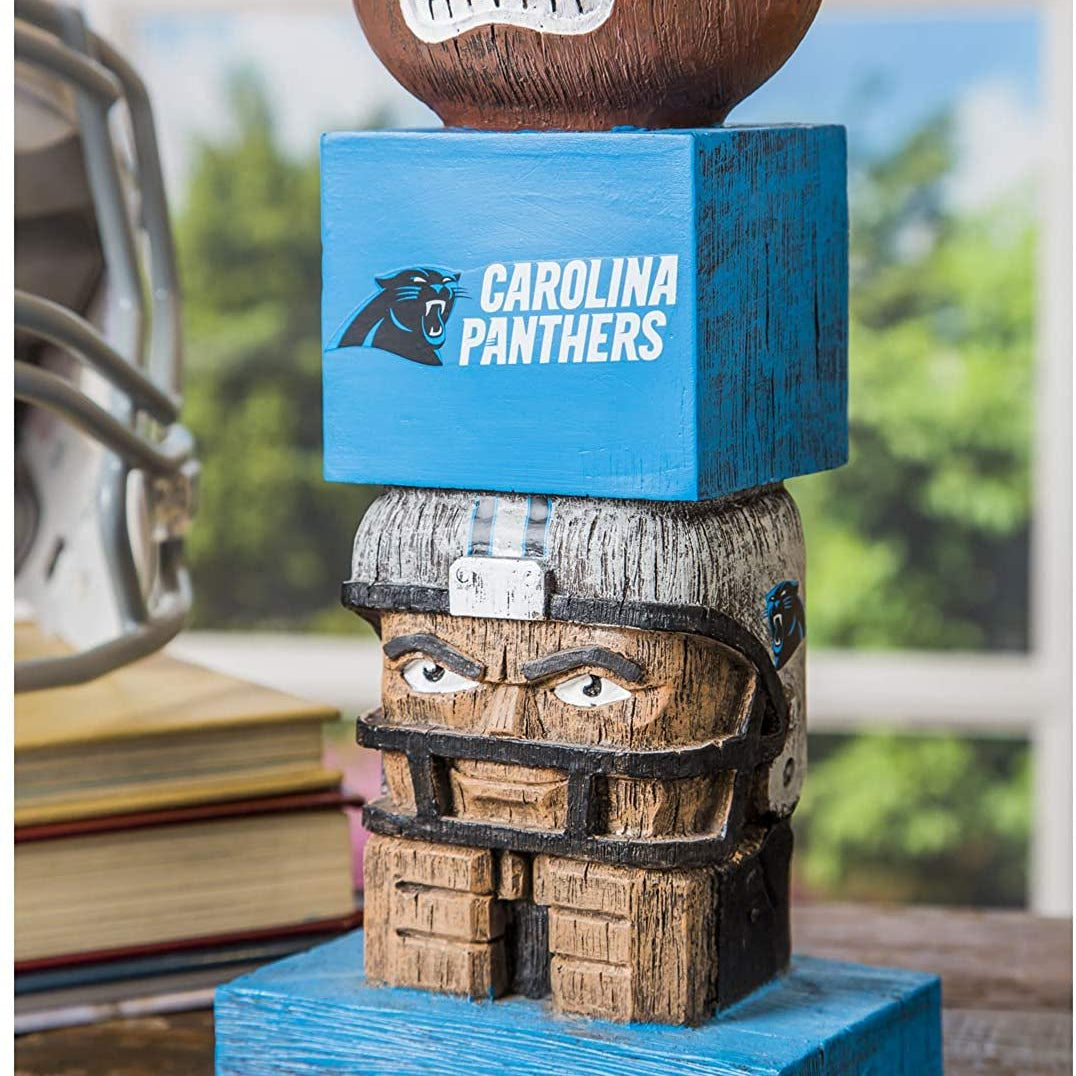 Carolina Panthers-themed wooden totem with football on top, placed indoors.