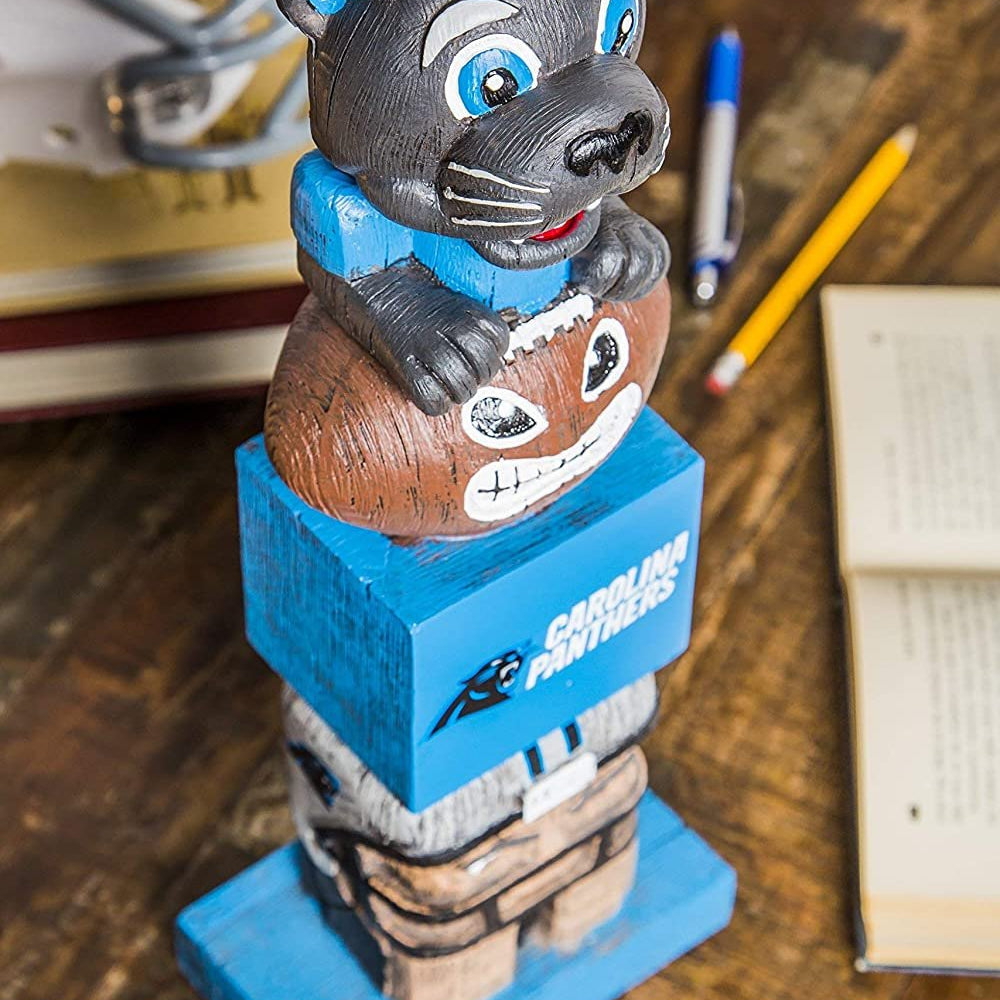 Wooden bobblehead figure of a panther on a blue base with a sports team logo, placed on a wooden surface with stationery items.