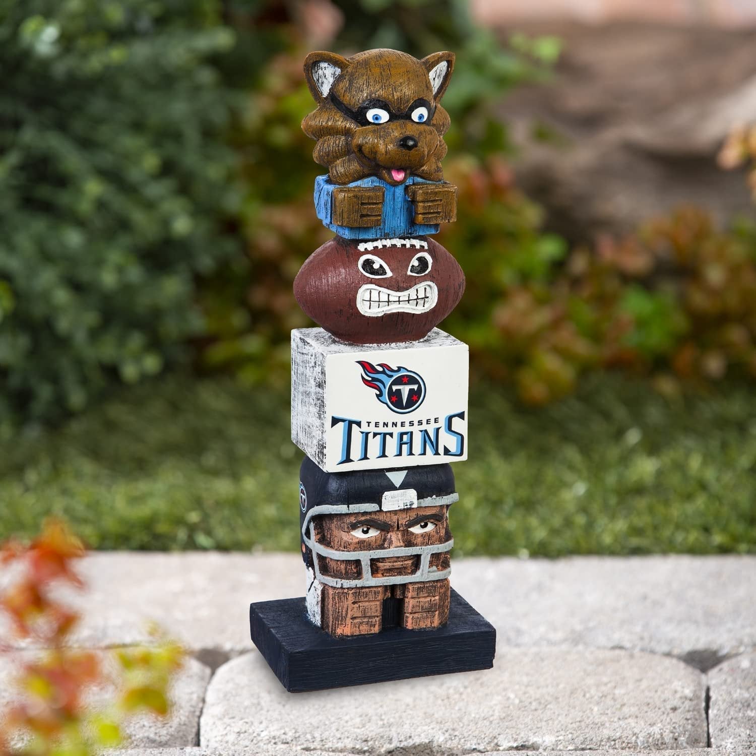 Tennessee Titans-themed totem pole figurine with cartoon character on top, set against a natural background.
