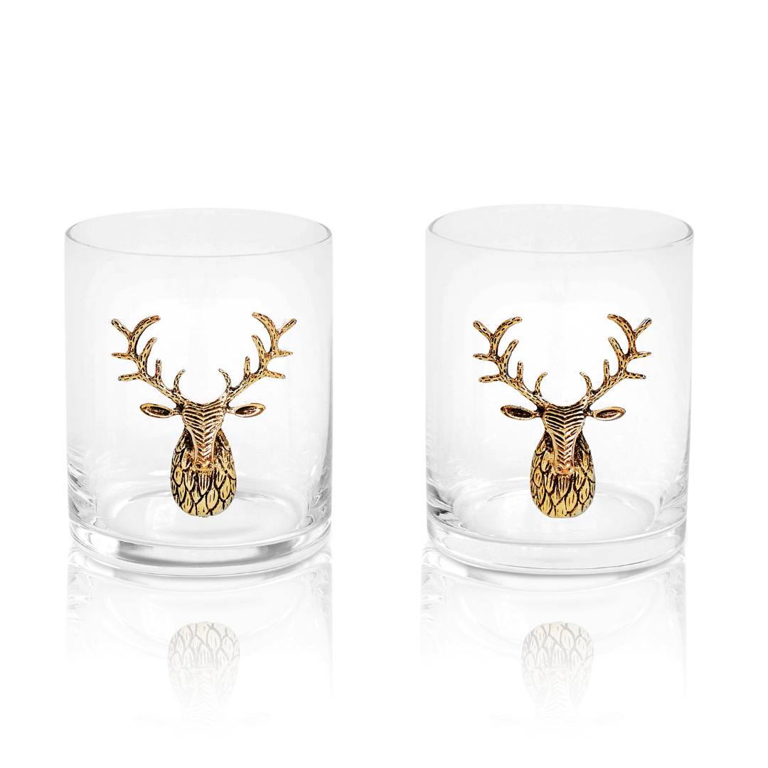 Two glass tumblers with gold deer head designs on a white background