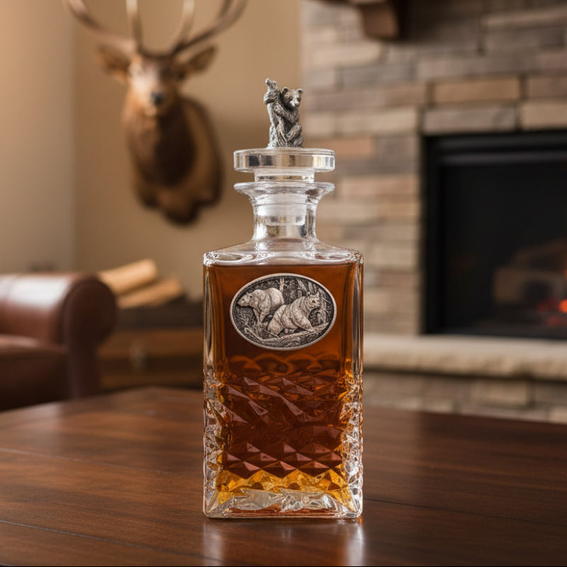 Decorative whiskey decanter with a silver bear finial on a white background