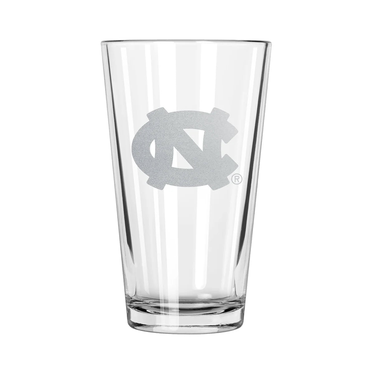 A clear pint glass with an etched design of the UNC Tar Heels logo.