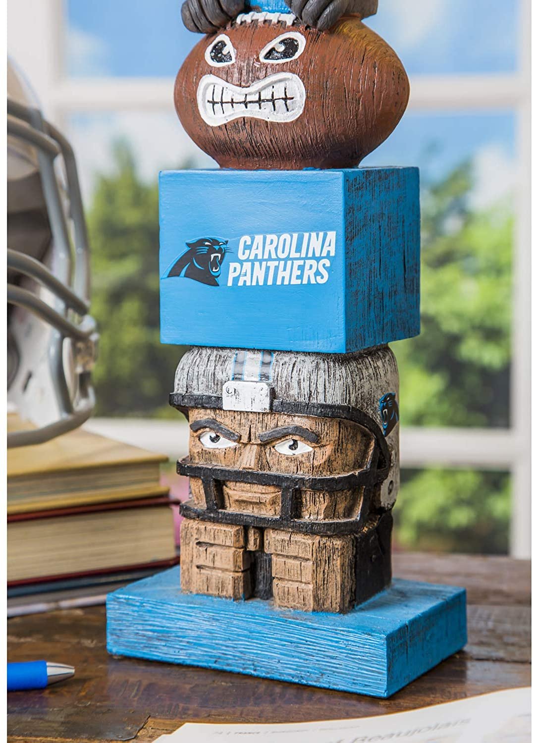 Carolina Panthers-themed wooden totem with football on top, placed indoors.