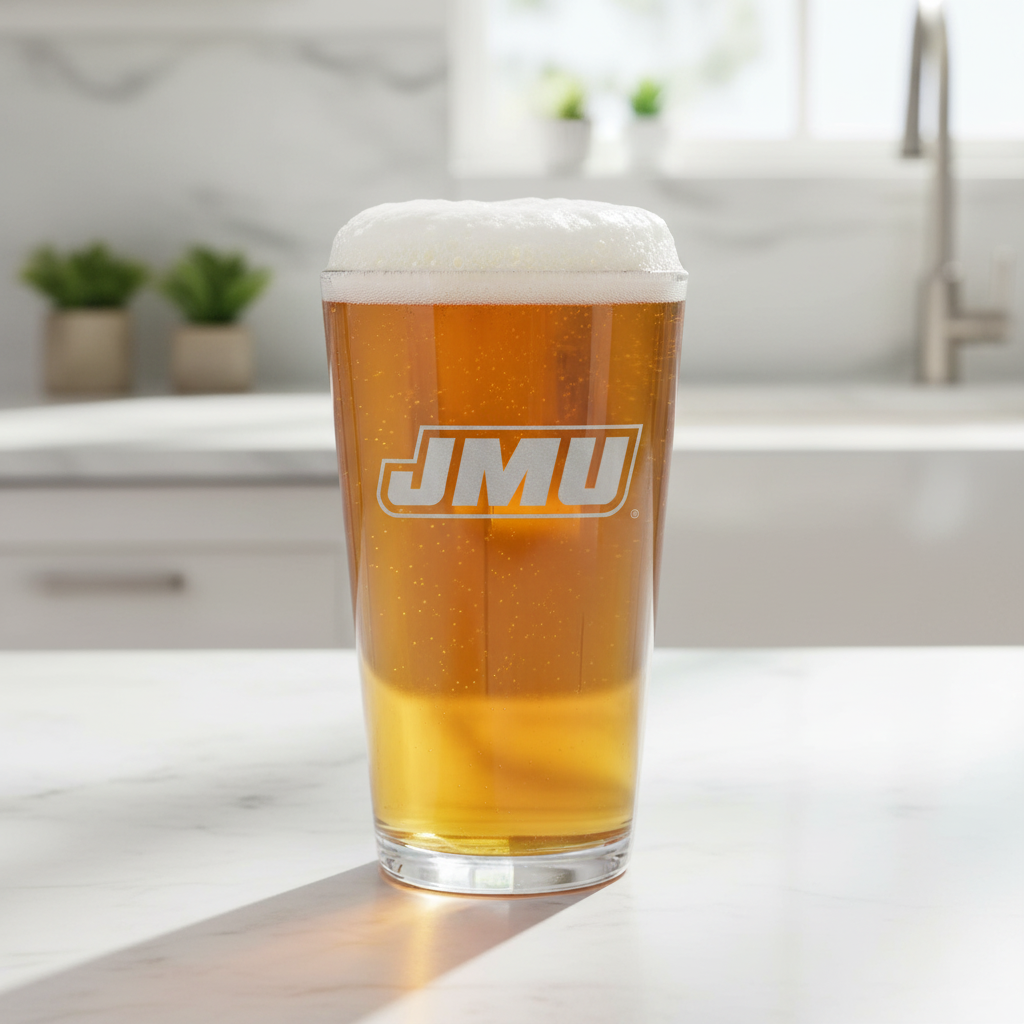 A clear etched pint glass with the James Madison Dukes logo.