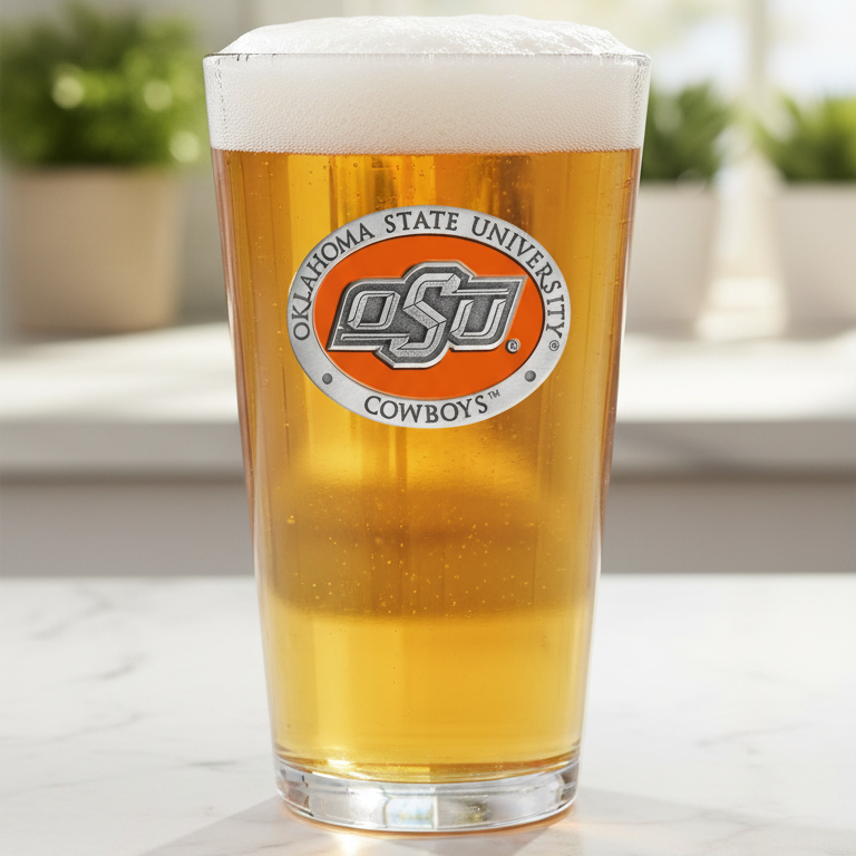Pint glass of beer with Oklahoma State University logo on a blurred indoor background