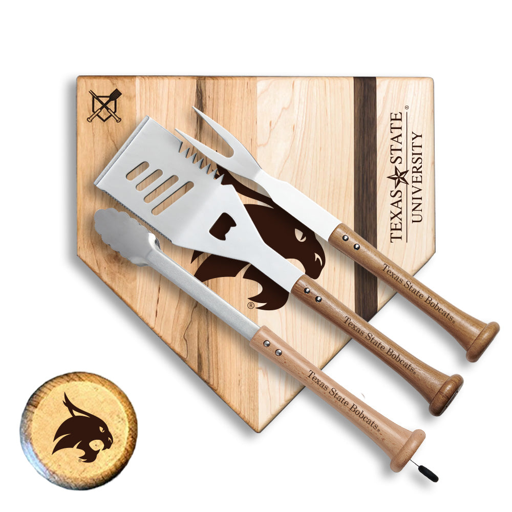 Two spatulas with wooden handles and a Texas State University logo on a cutting board.