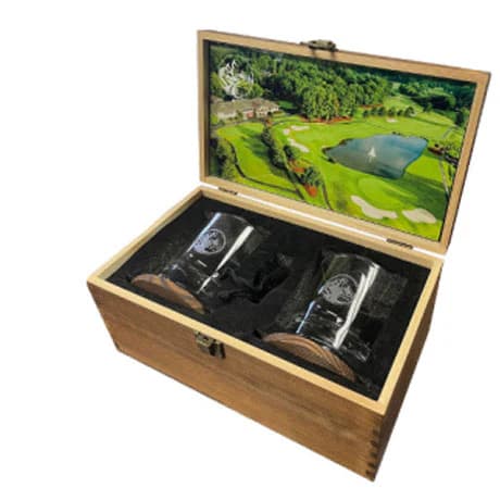 Two glass tumblers in a wooden box with a golf course photo on the lid.